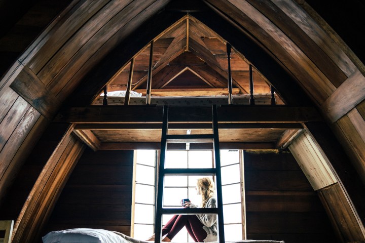 A woman sitting in a cabin looking out at the Alaskan Wilderness