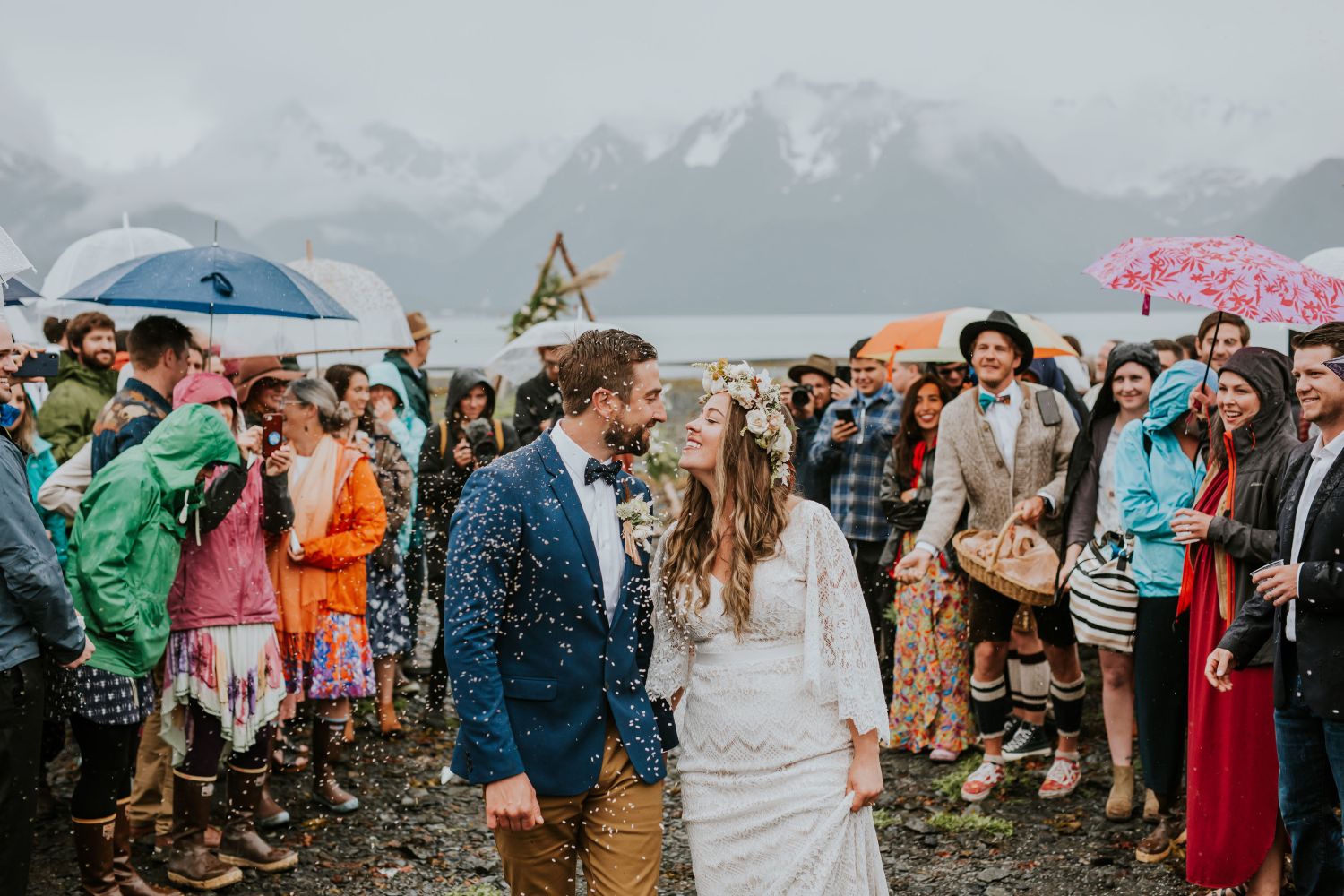 a group of people standing in the rain holding an umbrella